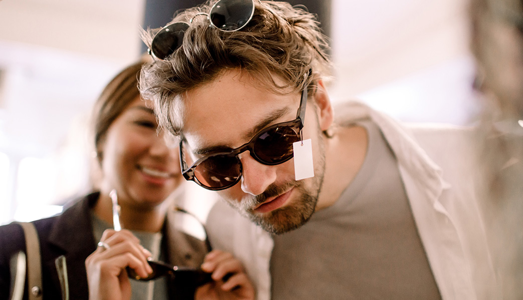 Ein Paar probiert Sonnenbrillen an