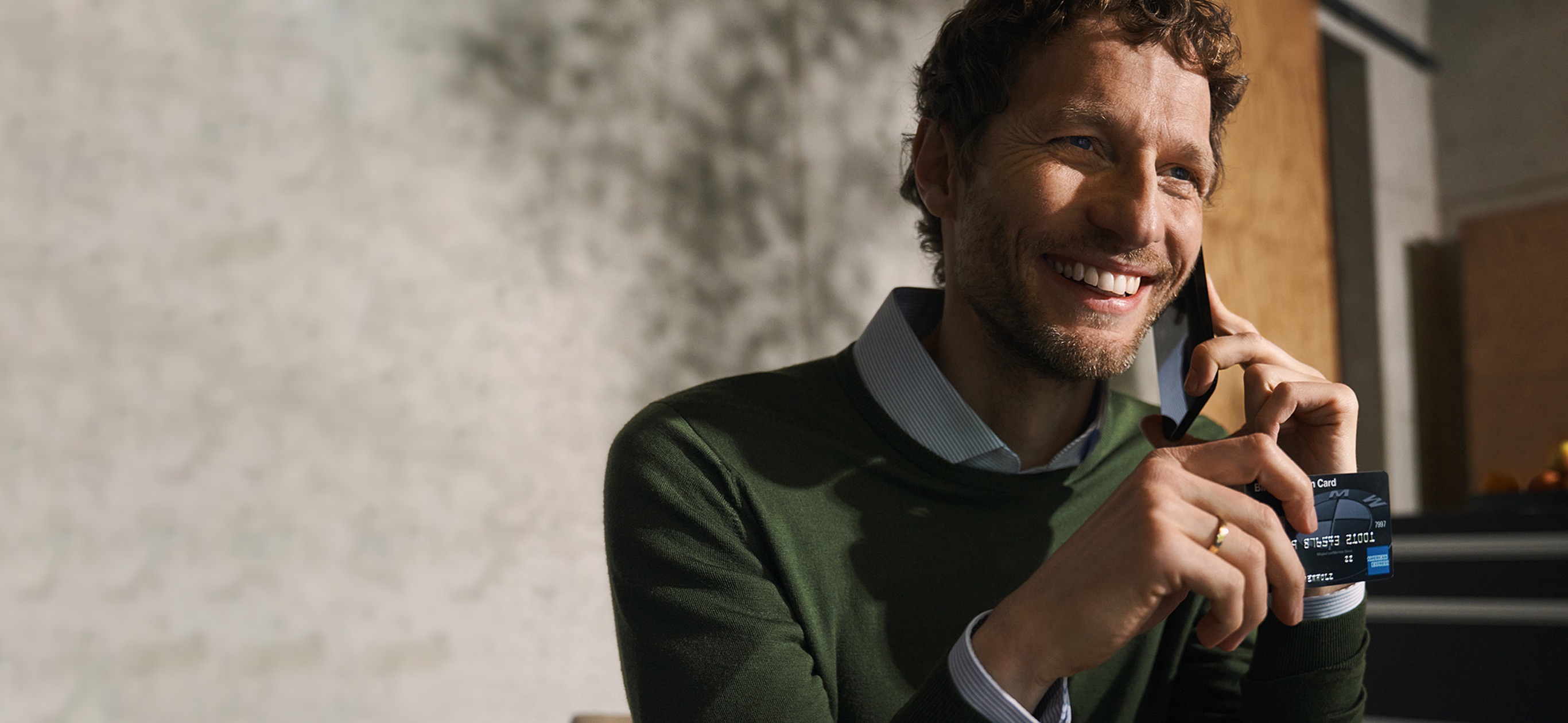 Mann mit BMW Carbo Karte in der Hand telefoniert