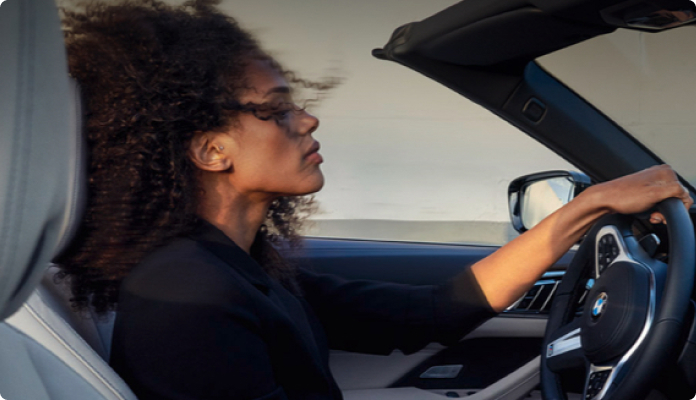 Frau fährt im Cabrio durch die Stadt