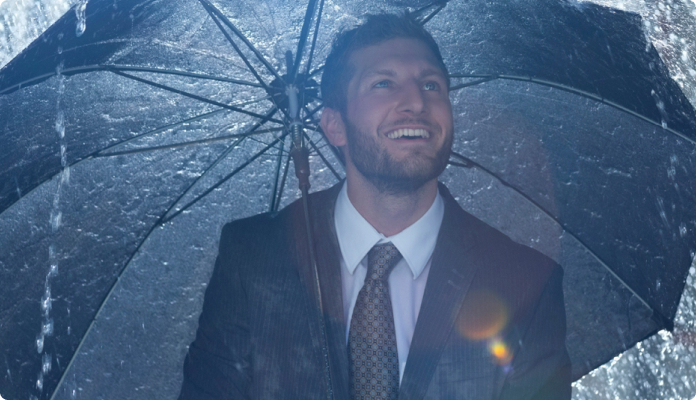 Geschäftsmann mit Regenschirm im Regen