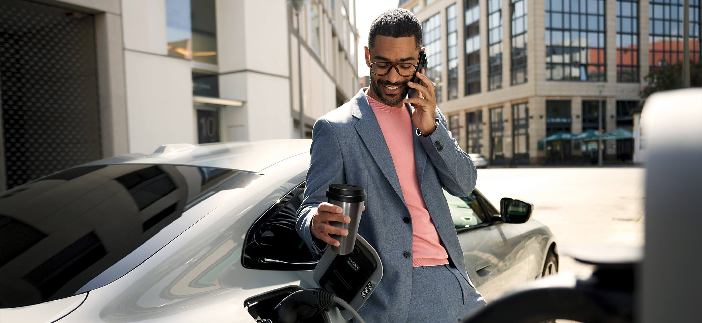 Mann lädt einen BMW an einer Ladesäule