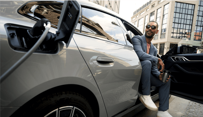Mann lädt einen BMW an einer Ladesäule