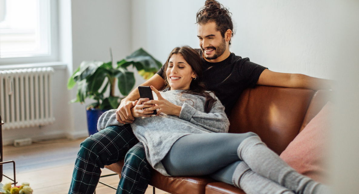 Paar mit Smartphone auf dem Sofa